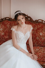 Beautiful brunette bride with light make-up in white dress  in an exquisite interior 