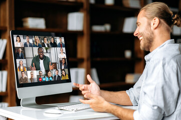 Successful caucasian young man talking on video conference with colleagues of different...