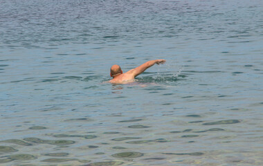 A man swims in the sea.
