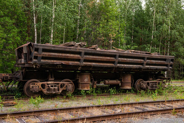 an abandoned Russian car on the rails in the forest