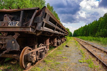 Fototapeta na wymiar an abandoned Russian car on the rails in the forest
