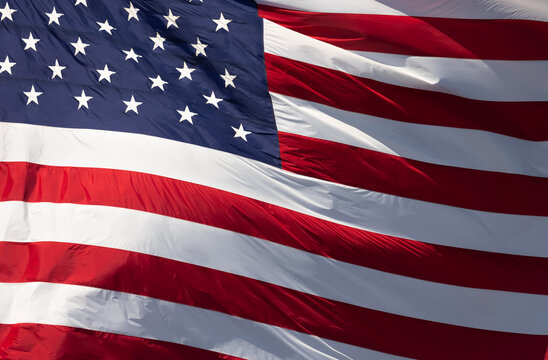 American Flag Waving In Wind Against a Deep Blue Sky.