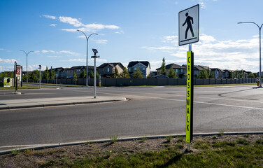 A pedestrian crosswalk with solar charging  LED warning lights at new development intersection in Airdrie Alberta Canada.