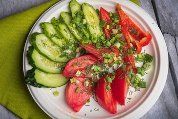 Tomatoes, cucumbers and bell peppers, cut into wedges. Vegetable mix. Summer fresh vegetable salad. Vegetables on a plate.