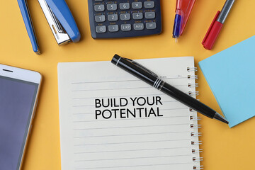 Motivational quote on Build Your Potential written on the notebook 