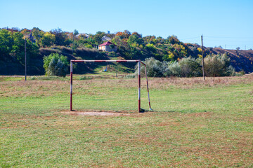 Fototapeta na wymiar Sport ground in the village . Abandoned Rustic Football Stadium . Football gate