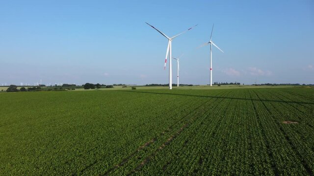 Energy transition: Renewable energies from wind power. Wind turbines in an agricultural field on a summer afternoon.