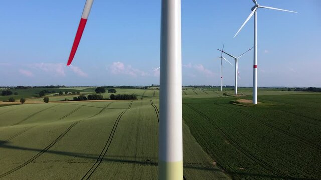 Energy transition: Renewable energies from wind power. Wind turbines in an agricultural field on a summer afternoon.