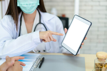 Asian woman doctor showing an information in tablet, a mockup blank screen tablet.