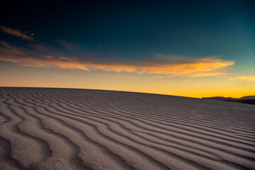 Fototapeta na wymiar Golden Light Over Shadowy Dunes In White Sands