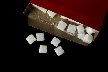 sugar cubes from the red box on black background.