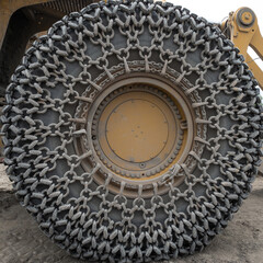 Quarry front loader wheel with a metal chain for tire protection on a sandy ground seen in Longmont, Colorado, USA