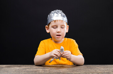 a beautiful red-haired boy with a homemade foil hat