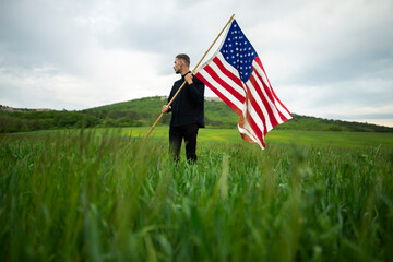 Young man with American flag in wheat field