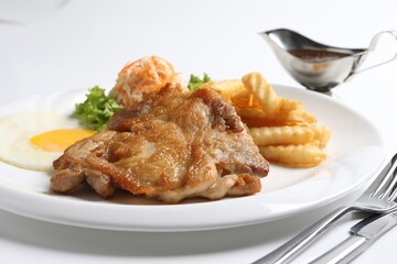 grilled golden bbq meat chicken cop pork cutlet beef steak with fried egg, French fries, coleslaw salad and black pepper sauce in pot western cuisine menu
