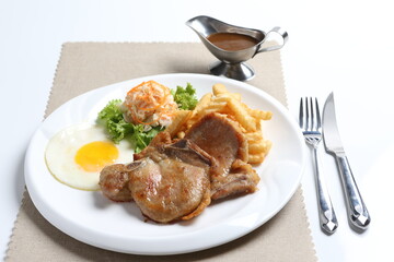 grilled golden bbq meat chicken cop pork cutlet beef steak with fried egg, French fries, coleslaw salad and black pepper sauce in pot western cuisine menu