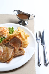 grilled golden bbq meat chicken cop pork cutlet beef steak with fried egg, French fries, coleslaw salad and black pepper sauce in pot western cuisine menu