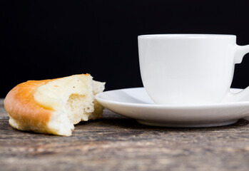 a delicious fresh bun and a cup of black aromatic coffee