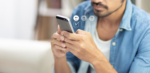 man pressing on mobile phone with happy icon for feedback review satisfaction service 