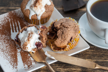 Sweet cherry muffin with ice cream and white cup with tea on a wooden background