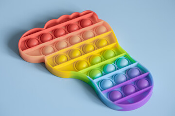 Close up rainbow Pop it fidget toy on blue background.