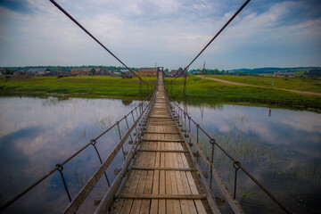old suspension bridge over a small river in the countryside