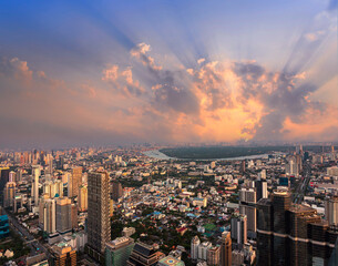 Fototapeta premium Golden Sunset lightbeam with Bangkok city of cityscape skyline with skyscraper building background in Central business district Bangkok, Thailand