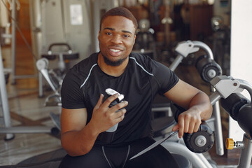 Obraz na płótnie Canvas A handsome black man is engaged in a gym