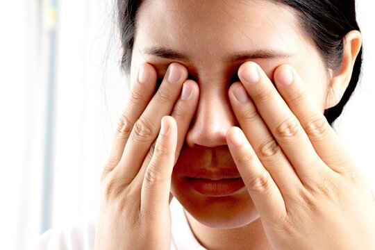 Overwork, stress. Asian businesswoman holding glasses feels pain, dry eyes or headache suffers from blurry poor vision.
