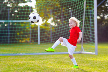 Kids play football. Child at soccer field.