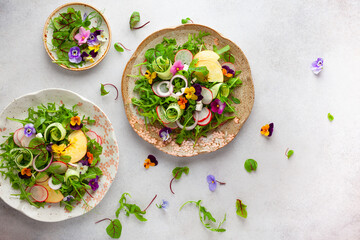 Delicious summer salad with edible flowers, vegetables, fruit, microgreens and cheese. Clean and...