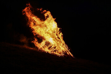 High flames at a winter solstice bonfire at night