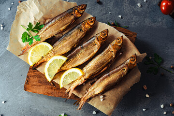 Fish. Smoked whitefish. Smoked fish on the table with toppings. Vegetables and fish. - obrazy, fototapety, plakaty
