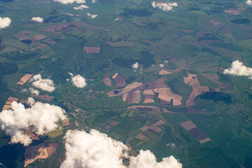 landscape under the wing of an airplane, bizarre outlines of fields and forests on the ground