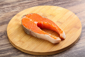 Raw salmon steak over board