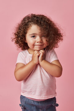 Charming kid standing on pink background