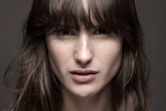 Serious female with makeup and freckles on nose