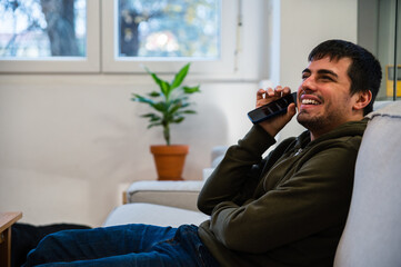 Cheerful blind man listening audio sitting on sofa