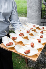 waiter serving different tapas of food at an event.