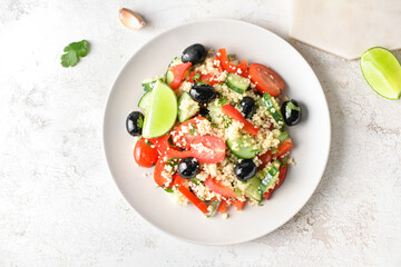 Plate with couscous and vegetables on light background