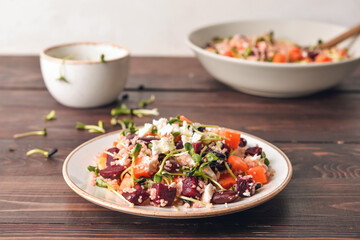 Plate with couscous and vegetables on wooden background
