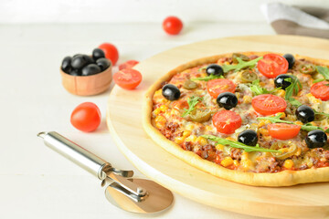 Board with tasty pizza on light wooden background