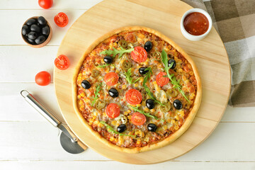 Board with tasty pizza and sauce on light wooden background