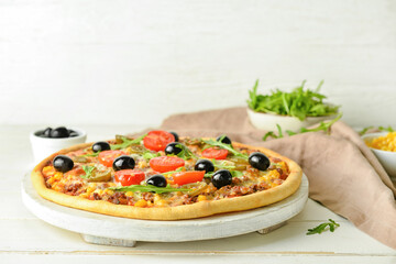 Board with tasty pizza on light wooden background