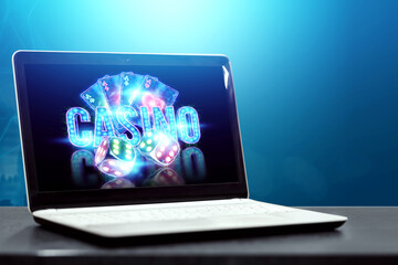 Concept for online casino, gambling, online money games, bets. Neon casino chips, casino inscription, poker cards, dice fly out of the laptop.