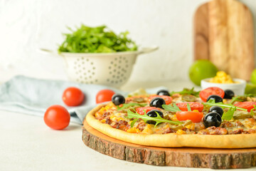 Board with tasty pizza on light background, closeup