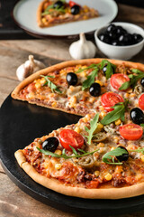 Board with tasty pizza on wooden background, closeup