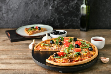 Board with tasty pizza on dark background