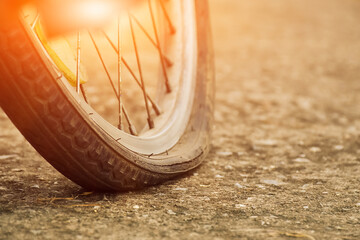 Close up view of bike which has flat tire and parked on the pavement, blurred background. Soft and...