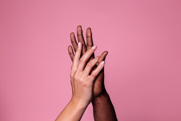 Hands of white woman and black man touching